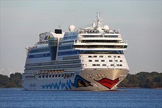 Cruise ship AIDA Sol leaving the port of Hamburg in the evening light on the Elbe
