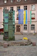 Minster fountain by Klaus Ringwald 1989 at the market place in front of the town hall with EU flag and Ukrainian flag