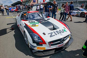 Mercedes SLS AMG GT3 with open wing doors lines up in grid lane of ADAC GT Masters car race