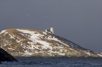 View of snow-covered island with lighthouse