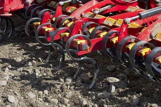 Close-up of Vaderstad Spirit 800S cultivator seed drill tines in a stony soil field