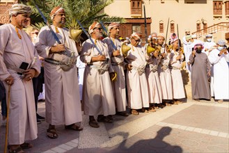 Men performing traditional songs during the Friday Goat Market in Nizwa