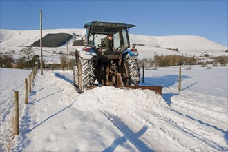 New Holland tractor clearing snow from farm track