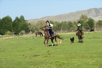 Two Kazakh horsemen in traditional dress