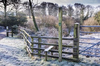 Frost on wooden fence with fence post and Public Footpath sign