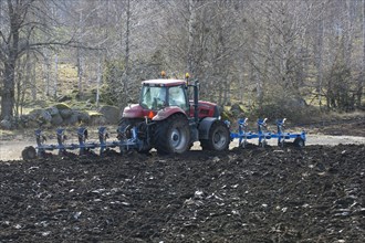 Tractor ploughing with front- and rear-mounted plough