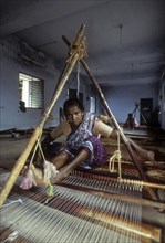 A woman weaving korai or cyperus mat in Pathamadai