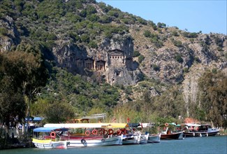 View of tourist boats on the river and Lycian rock tombs