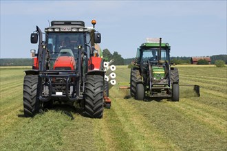 Tractors with roundabout rakes and balers turning cut grass and baling silage Sweden