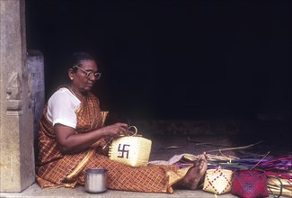 Old woman weaving palm leaf baskets in Chettinad