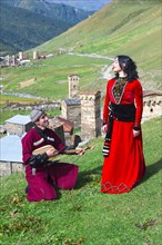 Georgian people from the folklore group playing panduri and dancing in traditional Georgian dress