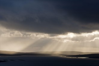 Stormy evening sky with sun rays over the coast