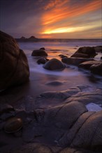View of eroded rock formations on the beach at sunset