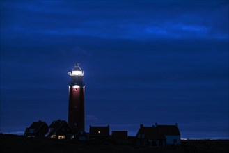Eierland lighthouse with lantern light over the Wadden Sea at night on the Dutch island of Texel