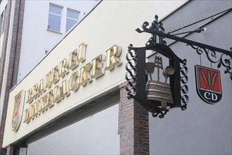 Lettering and pub sign of the Dinkelacker brewery at the entrance to the brewery in Tuebinger Strasse