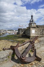 Old anchor and bell tower at the entrance gate to the medieval Ville Close in Concarneau
