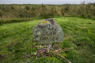 Flowers at the gravestone marking the mass grave of the fallen Jacobite soldiers of Clan Fraser on the battlefield of Culloden near Inverness