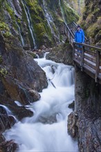Tourist looking at the waterfall in the Wimbachklamm gorge in Ramsau bei Berchtesgaden