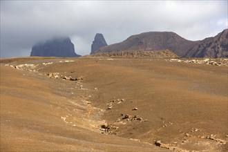 Dry landscape with yellow sand and volcanic peaks on the island of Sao Nicolau