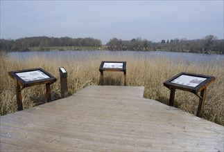 Boardwalk and information boards overlooking the lake in a flooded former limestone quarry