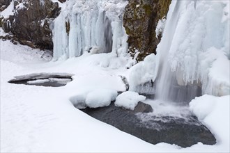 Frozen waterfall Kirkjufellsfoss on the SnÂµfellsnes peninsula in winter