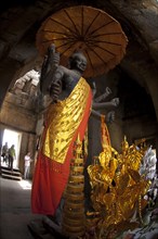 Standing deity with umbrella in Khmer temple