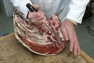 Butcher boning beef tenderloin