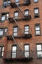Fire escape ladders on side of brick apartment buildings