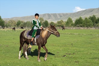 Kazakh boy in traditional dress on a horse