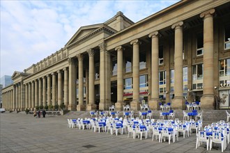 Tables and chairs of a street cafe in front of the Koenigsbau on Schlossplatz