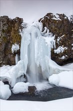 Frozen waterfall Kirkjufellsfoss on the SnÂµfellsnes peninsula in winter