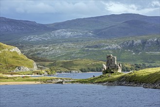 Tourists visit the 16th century castle ruins of Ardvreck on Loch Assynt in the Scottish Highlands
