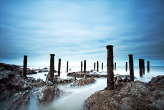Steel supports of the ruined Victorian pier visible on the shore at low tide