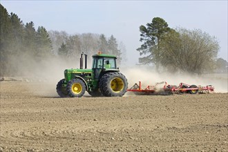 John Deere tractor pulling harrows