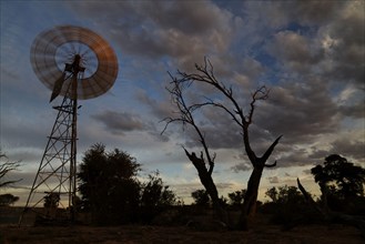 Wind pump in the desert at sunset