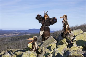 Creepy wooden devil figures on the summit of the Lusen in autumn