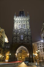 Gothic city gate tower illuminated at night