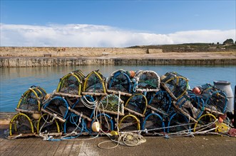 Pile of lobster pots stacked on quayside