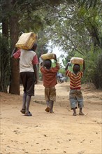 Children collecting water from a well and carrying it home