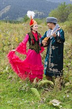 Kazakh man singing and playing dombra for a woman