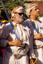 Men performing traditional songs during the Friday Goat Market in Nizwa