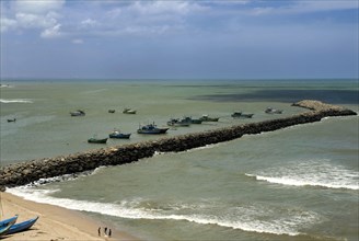 View of breakwater with moored fishing boats