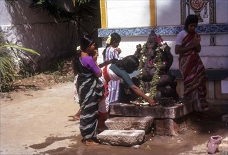 Women rounding the Ganesha during worship
