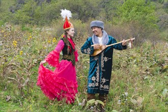 Kazakh man singing and playing dombra for a woman
