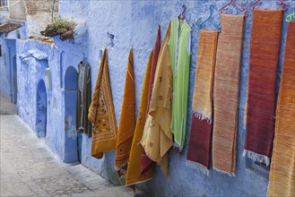 Blue houses and textiles for sale in an alley of the city