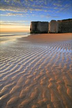 View of sandy beach and chalk cliffs at sunrise