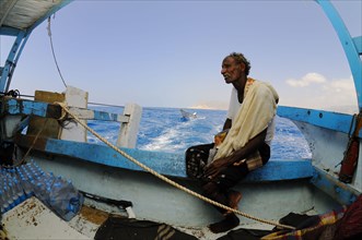 Local fisherman sitting on boat at sea