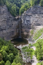 View of waterfall flowing over gorge cliff