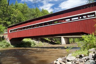 View of covered bridge crossing river