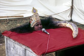 A woman performing a magic show like snake in a village exhibition